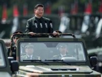 China's President Xi Jinping wore a Mao suit as he was driven in an open-top jeep past serried ranks of the People's Liberation Army, in a rare show of force in Hong Kong