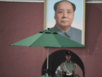 A Chinese paramilitary guard stands in front of a portrait of late communist leader Mao Zedong at the Forbidden City in Beijing on July 31, 2017, on the eve of the 90th founding anniversary of the People's Liberation Army (PLA). The PLA, originally called the Chinese Workers' and Peasants' Red Army, was founded in 1927 when Communist soldiers seized the southern town of Nanchang from Nationalist Party ('Kuomintang') armies in what is known today as the Nanchang uprising. / AFP PHOTO / FRED DUFOUR (Photo credit should read FRED DUFOUR/AFP/Getty Images)