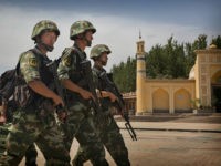 KASHGAR, CHINA - JULY 31: Chinese soldiers march in front of the Id Kah Mosque, China's largest, on July 31, 2014 in Kashgar, China. China has increased security in many parts of the restive Xinjiang Uyghur Autonomous Region following some of the worst violence in months in the Uyghur dominated area. (Photo by Getty Images)