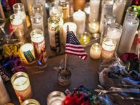 LAS VEGAS, NV - OCTOBER 3: A U.S. flag is placed in the middle of flowers and candles at a vigil that was held for the victims along the Las Vegas Strip a day after 59 people were killed and more than 500 wounded at the Route 91 Harvest Country Music Festival on Monday, October 2, 2017, in Las Vegas, NV. (Photo by Salwan Georges/The Washington Post via Getty Images)